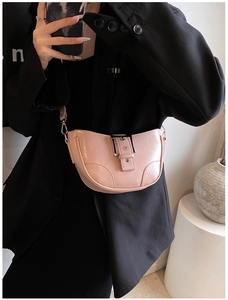 Détail du sac bandoulière rose en similicuir avec texture brillante et large ceinture