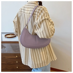 Detail of purple lychee textured PU leather crescent bag worn over the shoulder