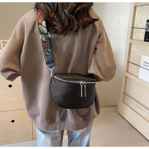 Détail du sac bandoulière demi-lune noir avec sangle jacquard colorée et double zip