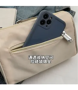 Détail du sac bandoulière beige en nylon avec poche zippée pour rangement de smartphone