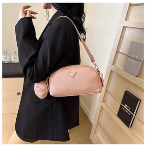 Detail of pink lychee leather crossbody bag with matching detachable triangle coin pouch