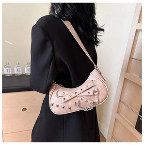 Detail view of pink PU leather crescent bag with punk eyelets and silver hardware