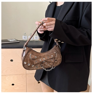 Detail of vintage brown shoulder bag with silver studs and metal chain punk accents