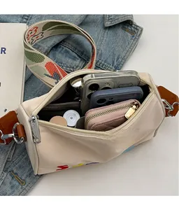 Vue intérieure du sac en toile beige montrant la grande capacité pour mobile et portefeuille