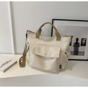 Chic beige canvas tote bag with adjustable brown straps and fashion label detail