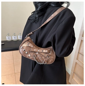 Close-up of vintage brown PU leather shoulder bag with silver studs and metal chains