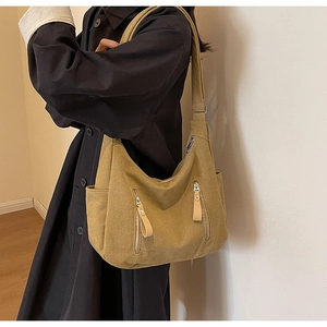 Detail view of the mustard canvas crossbody bag showing pockets and adjustable strap