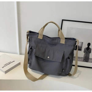 Deep grey canvas tote bag with beige straps and front flap pocket for spring 2024