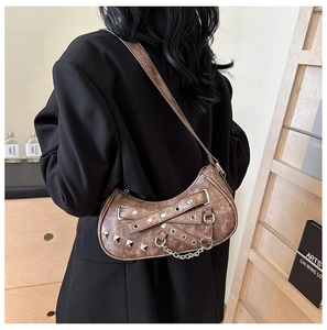 Detail of vintage brown PU shoulder bag with silver studs and chain on a black blazer