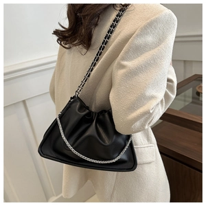 Close-up of black pleated cloud bag in lychee pattern leather with silver chain strap
