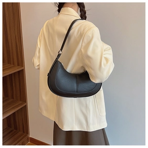 Detail of black pebbled leather hobo bag with silver ball hardware worn by a model