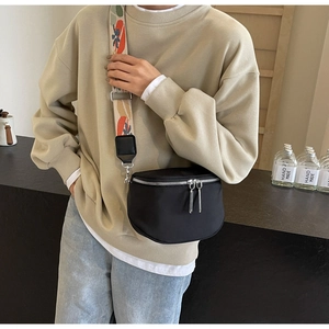 Détail du sac demi-lune noir avec bandoulière jacquard colorée et double fermeture