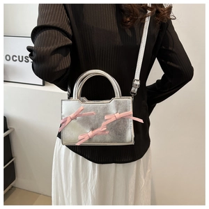 Silver PU mini handbag featuring decorative pink silk bows and a white shoulder strap