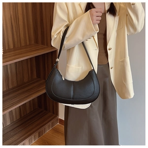 Side view of black crescent hobo bag with pebble leather texture and adjustable strap