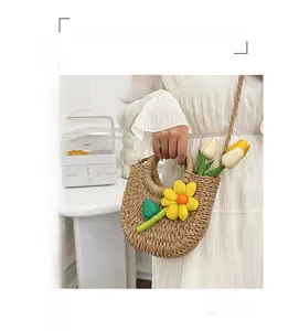 Vue détaillée du sac en paille tissé à la main avec fleur jaune et bandoulière