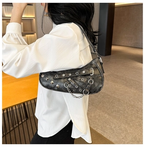 Detail of black pleated saddle bag with silver studs and punk style hardware decoration
