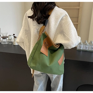 Detailed back view of a minimalist dark green canvas crossbody bag with leather trim