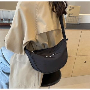 Détail du sac bandoulière noir en demi-lune avec logo bou Gu et large sangle confort
