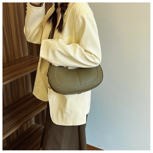 Olive green hobo bag with lychee texture leather on a model in a minimal setting