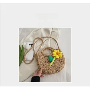 Détail de la texture en paille tressée avec une fleur jaune décorative sur le sac à main