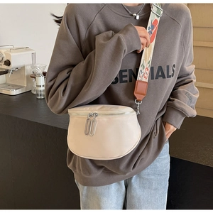 Détail du sac bandoulière beige en demi-lune avec double fermeture éclair et sangle fleurie