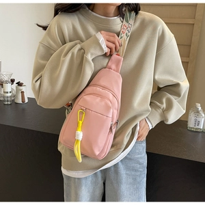 Pink nylon crossbody bag detail with floral embroidery strap and braided zipper pullers