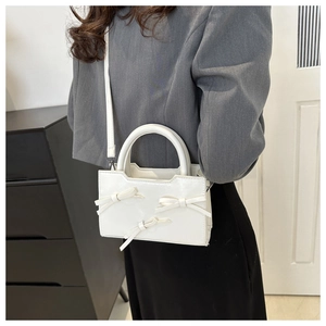 White PU crossbody bag with elegant bow accents and detachable shoulder strap detail
