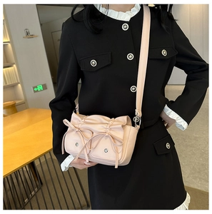 Detail view of pink PU crossbody bag with elegant bow decor and pleated design for women