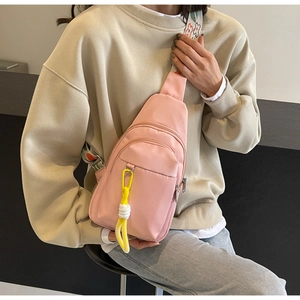 Detailed shot of pink canvas crossbody bag with floral embroidery strap and yellow carbine