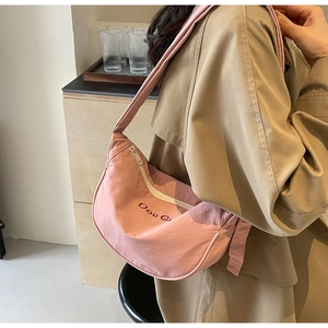 Détail du sac bandoulière demi-lune rose en toile avec logo Dou Gu et large bandoulière