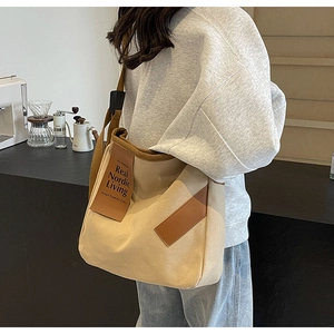 Detailed view of beige canvas crossbody bag with Real Nordic Living leather patch