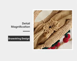 Detail magnification of woven straw handbag featuring drawcord closure and cherry decor