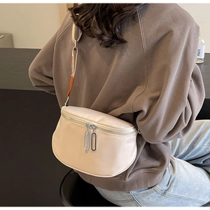 Détail du sac bandoulière en nylon beige avec double fermeture éclair et large sangle en tissu