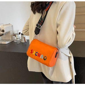 Détail du sac bandoulière orange en tissu Oxford avec broderie et sangle en jacquard