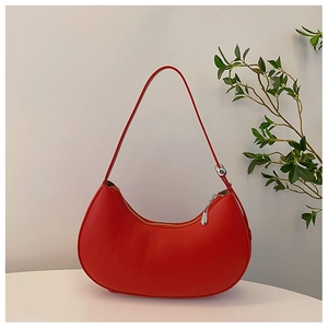 Minimalist red hobo shoulder bag in pebble leather with sleek crescent shape on white surface