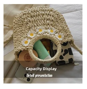 Internal capacity of woven straw handbag featuring 3D daisy appliqués and daily items