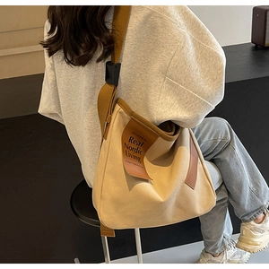Detail of canvas crossbody bag with leather patch showing Real Nordic Living text