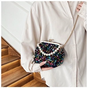 Detail of colorful sequined evening bag with large pearl handle and gold chain strap
