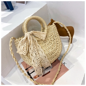 Minimalist beige woven straw handbag with white lace bow detail and round top handles