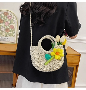 Détail de la texture tissée crème et des ornements floraux sur le sac à bandoulière tendance