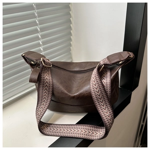 Brown vintage faux leather half-moon shoulder bag with a colorful woven strap