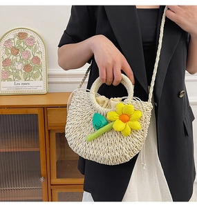 Détail du sac à main en paille tressée beige avec fleur jaune et doublure à cordon