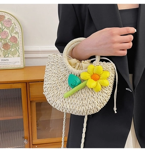 Détail d'un sac à main tressé crème avec fleurs 3D et fermeture par cordon serrage