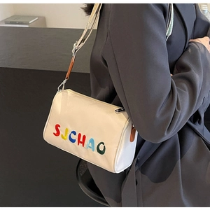 Détail de la broderie SUCHAO colorée et de la bandoulière tissée du sac à bandoulière crème