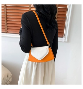 Détail du sac bandoulière bicolore orange et blanc avec décor cœur en 3D