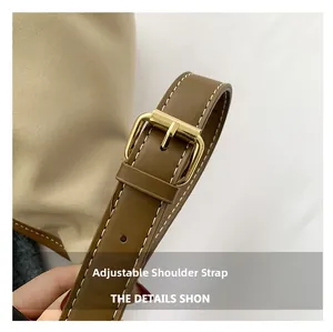 Detail of adjustable dark brown leather strap with gold buckle and white stitching