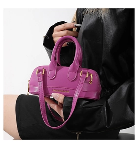 Detail of purple mini Boston handbag with gold logo lettering and smooth PU leather
