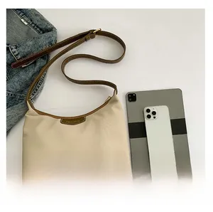 Flat lay of vintage beige canvas hobo bag with brown leather trim and accessories