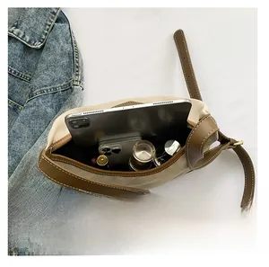 Interior view showing large capacity of the beige nylon bag with leather trim details
