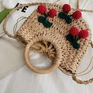 Handwoven straw handbag with 3D cherry accents and drawstring lining for spring 2024